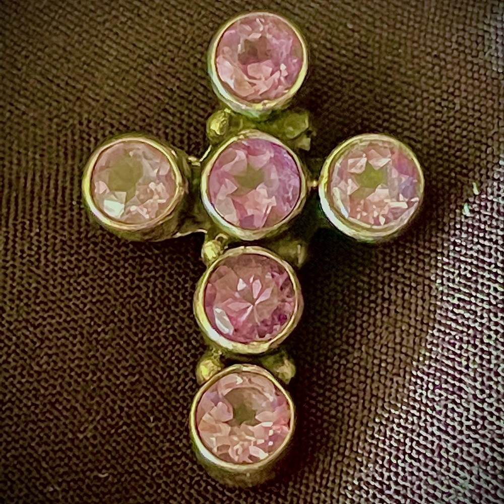 A silver cross with amethysts stones
